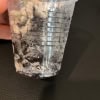 Hoya plant cutting in a clear plastic cup with soil, ready for propagation.